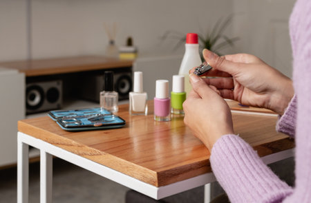 Woman cutting her nails while doing manicure session in her living room. Close up pictureの写真素材