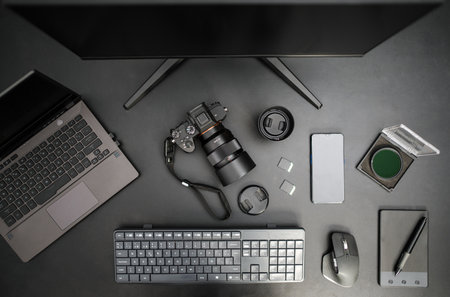 Top view of photographer workplace with camera, computer, lens, mobile, graphic tablet and accessories. black backgroundの写真素材