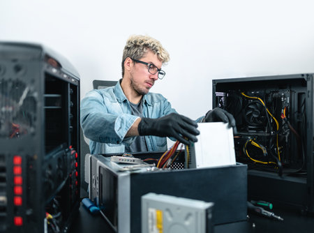 Man with eyeglasses doing pc maintenance on desktop computer. white backgroundの写真素材