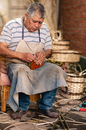 Old man making wicker handles for craft wicker baskets. Latin and Hispanic Culture. portrait photographyの写真素材