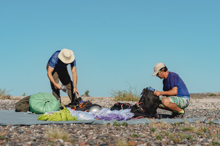 Two men prepare everything on the floor for flying with paraglider. Extreme sports conceptの写真素材