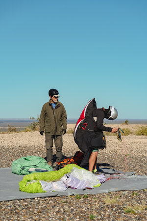 Two adult men paragliders getting ready for flight at the top of a hill. portrait photographyの写真素材