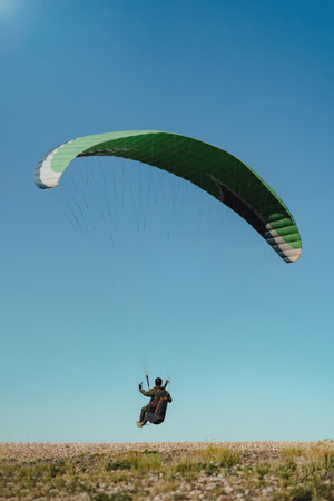 Paraglider takes off from land on a sunny day with blue sky. portrait photographyの写真素材