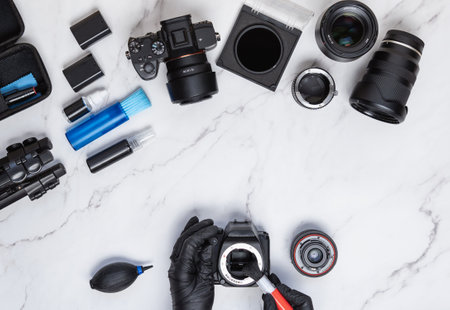 Modern camera cleaning kit layout on white marble background with hand wearing gloves while cleaning sensor. Photography and entrepreneur conceptの写真素材