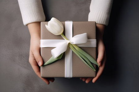 Top view of hands holding gift box with flower. Generative AIの素材