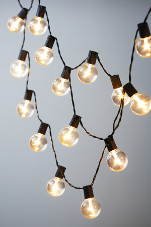 Lightbulbs hanging over white background. vertical shotの素材