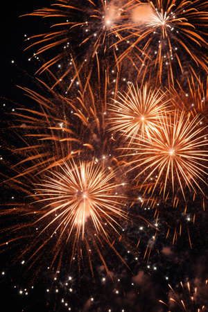Golden fireworks explode above the dark night. New Year concept. vertical shotの素材