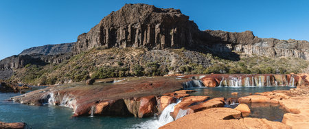 Scenic view of waterfalls along the Rio Agrio, with unique rock formations and clear blue sky. Neuquen, Patagonia Argentinaの写真素材