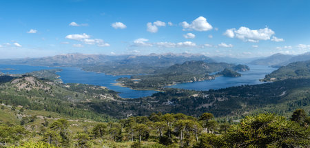 Scenic view of Villa Pehuenia and Lake Alumine surrounded by mountains and ancient araucaria trees on a beautiful day. Neuquen, Argentinaの写真素材