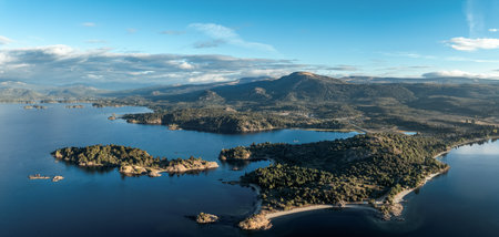 Panoramic view of Alumine lake surrounded by mountains and forests under a cloudy sky. Villa Pehuenia, Neuquen, Patagonia, Argentinaの写真素材