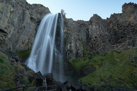 Man admiring majestic La Fragua Waterfall from lookout point, a natural spectacle of water and rock....