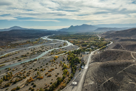 Aerial panoramic view of Neuquen river in Chos Malal through arid land and highway. Patagonia Argentinaの写真素材