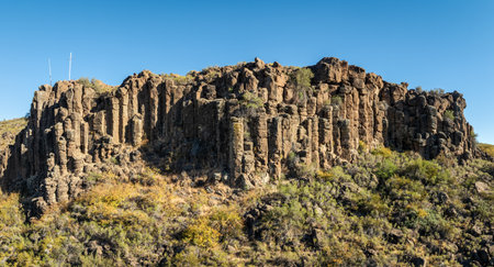 Cliff face with distinct columnar basalt formations, typical of volcanic activity. Villa del Nahueve, Neuquen, Argentinaの写真素材