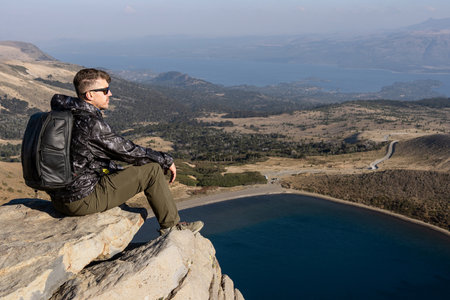 Man Relaxing at Scenic Overlook of Batea Mahuida Viewpoint. Villa Pehuenia, Neuquen, Argentinaの写真素材