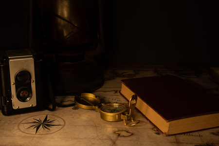 Dark setting old camera, lantern, compass, journal and map. planning an adventre