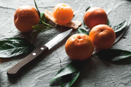 Citrus on table: mandarin, tangerine with a knife. Fresh organic juicy fruits.の写真素材