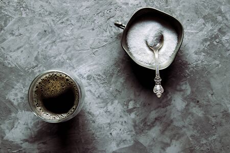 Glass cup of fresh coffee with spoon of brown sugarの写真素材