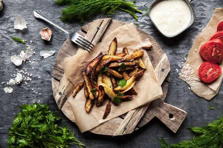 Tasty french fries on cutting board, on wooden table background