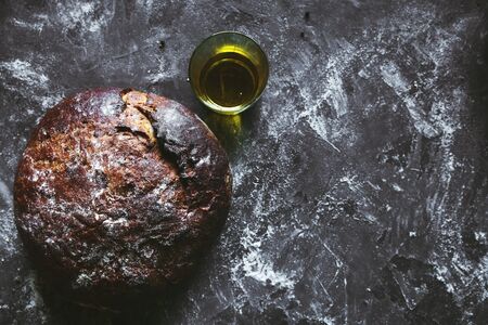 Bread on a black background with flour and oil. The bread is on the towel. homemade food