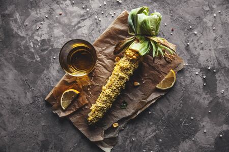 Grilled corn cobs with sauce, coriande on old wooden background. Mexican food. Top view. Copy space, healthy food, vegetablesの写真素材