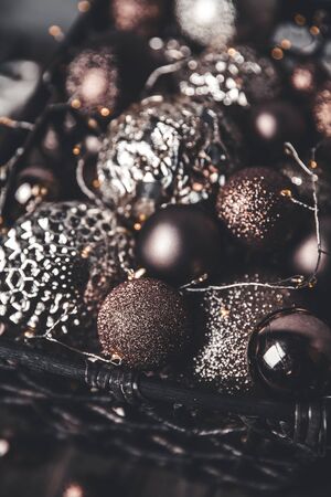 vintage christmas, new Year toys and decoration in basket on brown wooden table with garlands, copy spaceの写真素材