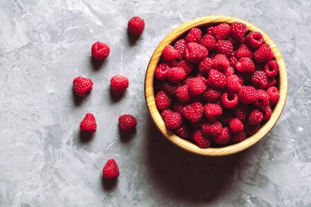 raspberries and blackberries in wood bowl on gray table, vintage