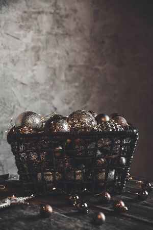 vintage christmas, new Year toys and decoration in basket on brown wooden table with garlands, copy spaceの写真素材