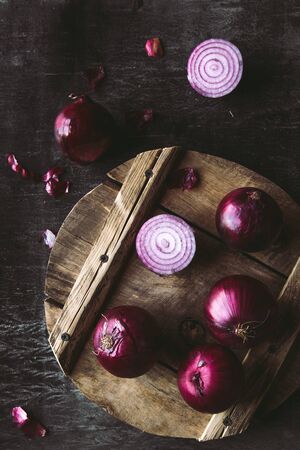 Red Onion Slices on wooden board with dark backgroundの写真素材