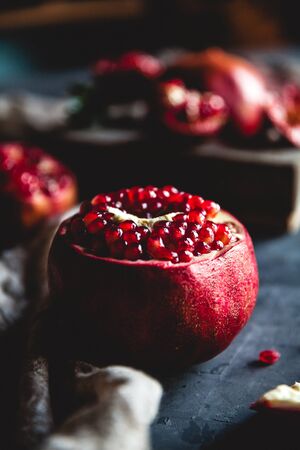 Fresh pomegranate in a wooden box. On a gray background. Top view. Copy space.の写真素材