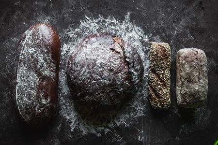 Group of different types of bread on black background