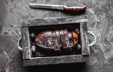 bread in an old wooden box already cut into pieces. food