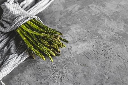 Asparagus in a kitchen towel on a gray background. healthy foodの写真素材