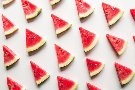 Seamless summer pattern. Watermelon slices, seeds and green leaves on white background, top viewの写真素材