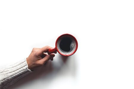 red coffee cup in hands on white backgroundの写真素材