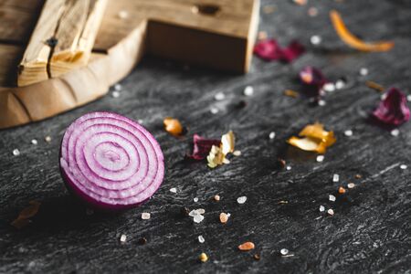 Red Onion Slices on wooden board with dark background