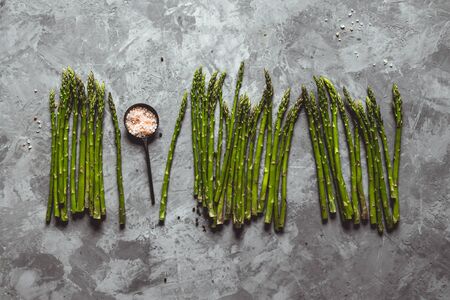 Fresh bunch of asparagus with smooth daylight on grey stone background/top view and free space for textの写真素材