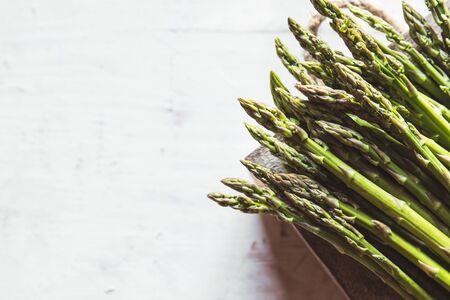 asparagus on a cut board on an old white backgroundの写真素材