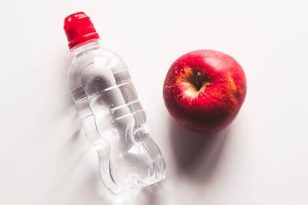 Bottle of sparkling water and red appleの写真素材