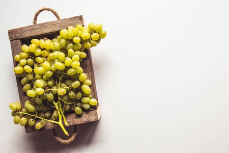 Wooden box with red grapes isolated on white background.の写真素材