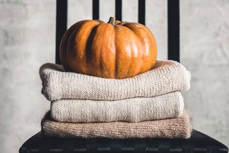 A stack of warm knitted sweaters on a white background. Autumn concept.の写真素材