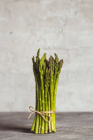 Fresh bunch of asparagus with smooth daylight on grey stone background/top view and free space for textの写真素材