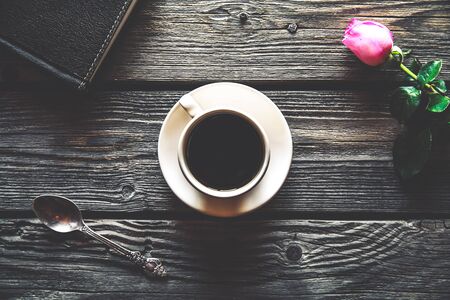 Fresh roses with diary and cup of coffee on wooden table, top view. flowers, hot drinkの写真素材