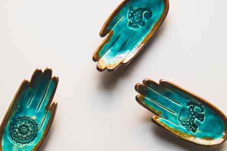 unusual turquoise plate in the shape of a hand on a white background. Ethnic themeの写真素材