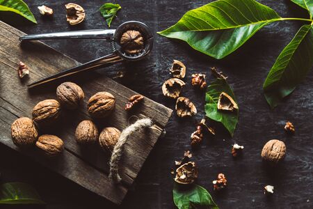 Walnuts on dark vintage table. healthy food. Nuts are scattered on a cutting board. Old vintage...