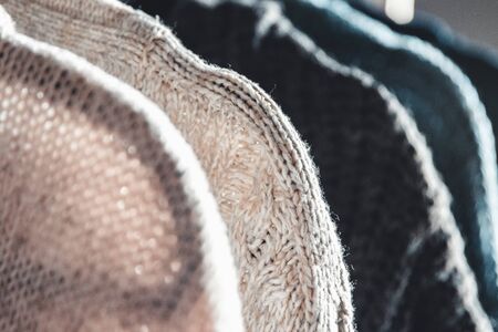 Collection of warm sweaters hanging on rack against graybackground, closeupの写真素材