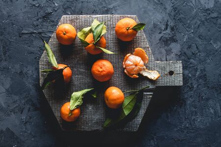 Group of three whole one piece of fresh orange mandarin on wooden cutting board. eco vegetarianism. PNOV2019の写真素材