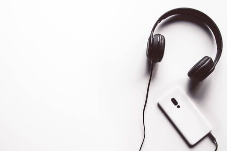 Headset and a phone on a white background. Ready to listen to music.