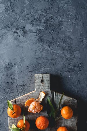 Group of three whole one piece of fresh orange mandarin on wooden cutting board. eco vegetarianism. PNOV2019の写真素材