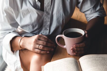 A woman is reading a book. Education, training, learning, hobby. Manicureの写真素材