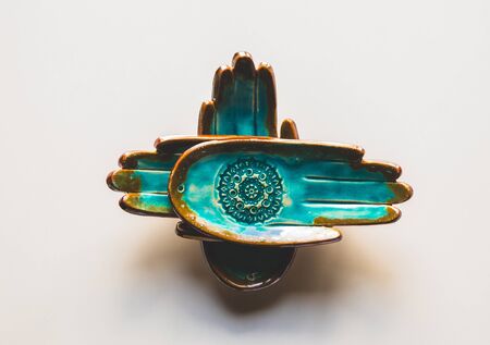 unusual turquoise plate in the shape of a hand on a white background. Ethnic themeの写真素材
